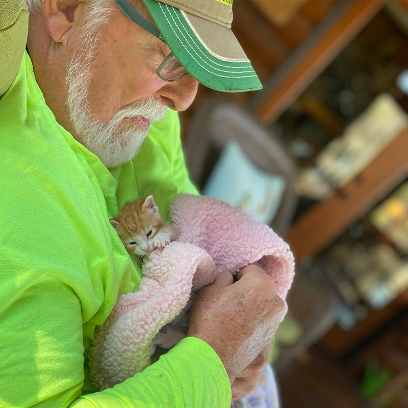 Abuelo holding Chudo the orange kitten