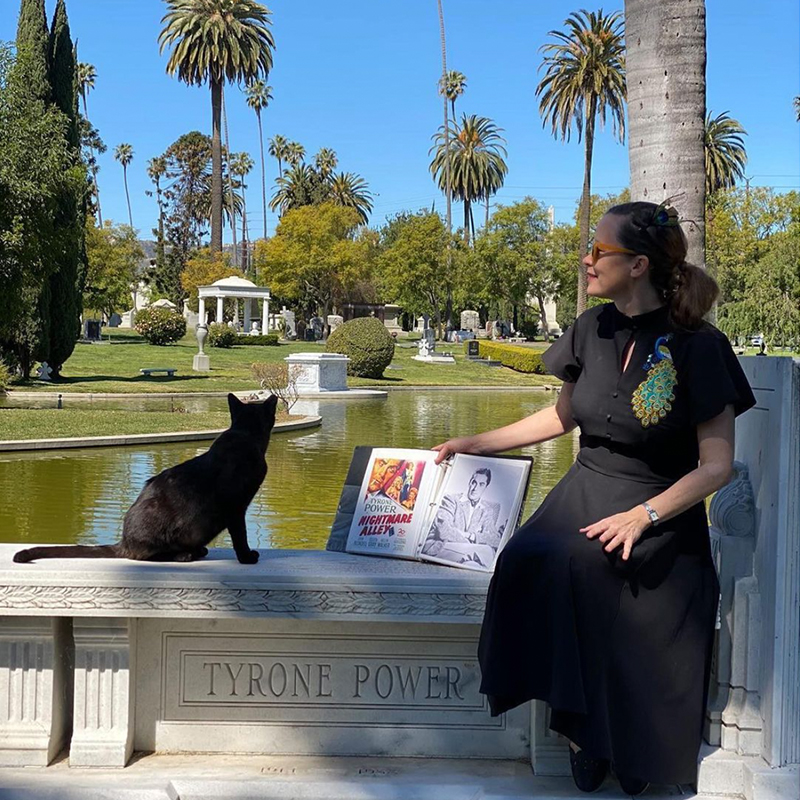 Tour guide Curry the Bible with a black cat at Forever Hollywood Cemetery in Los Angeles