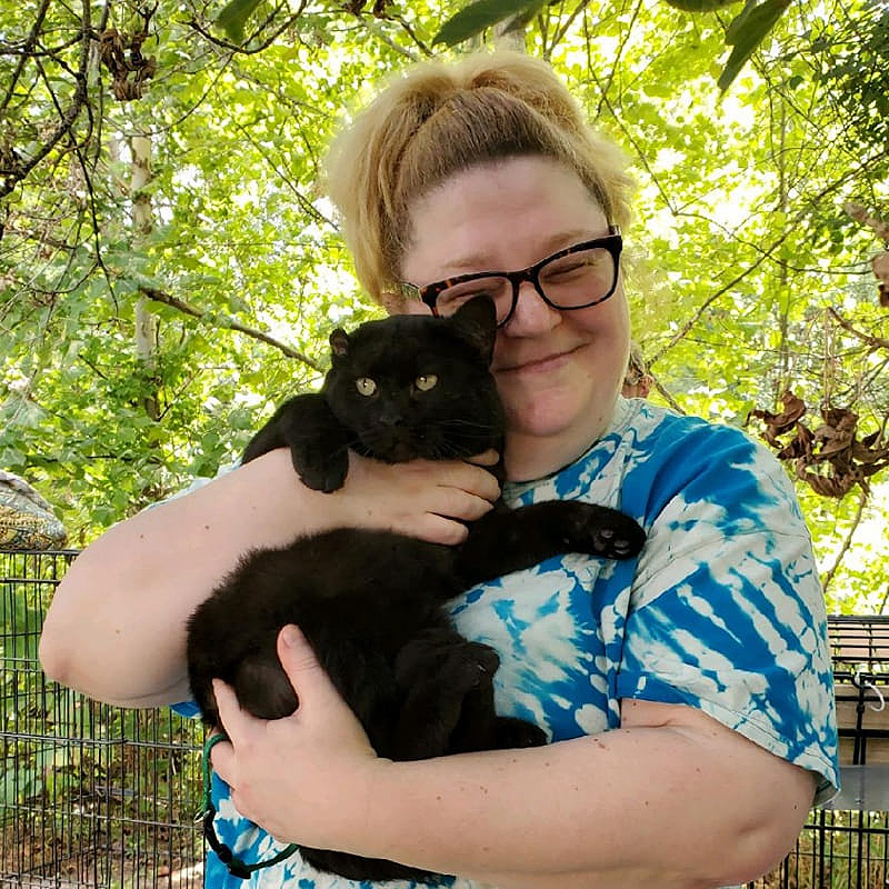 Woman holds black cat