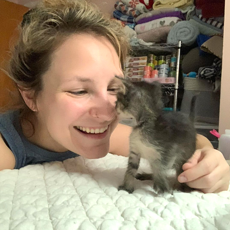Heather smiling with foster kitten after seeing improvement, ducky the kitten