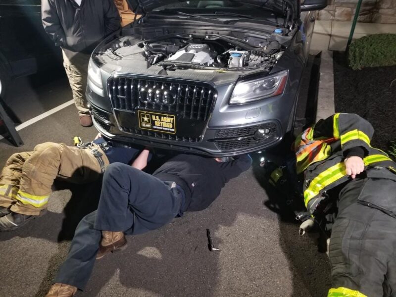Lincoln Fire Department working under a car.