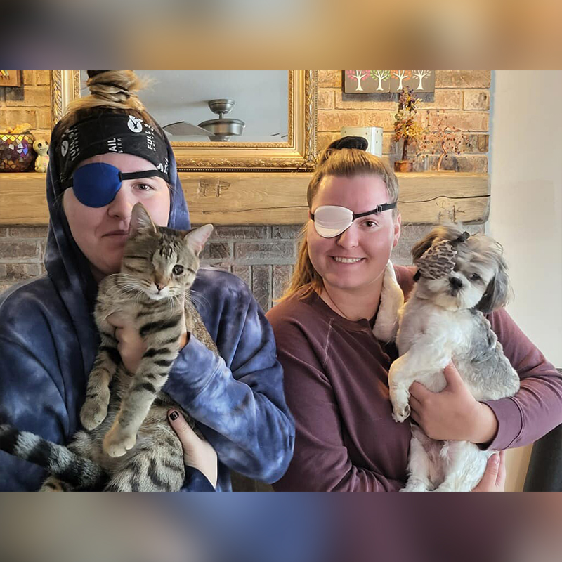 Family poses with eye patches after adopting foster kitten Doug, who lost an eye due to feline herpes, 2