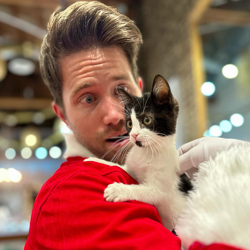 Nathan Kehn with Domino the kitten making faces, Young Santa